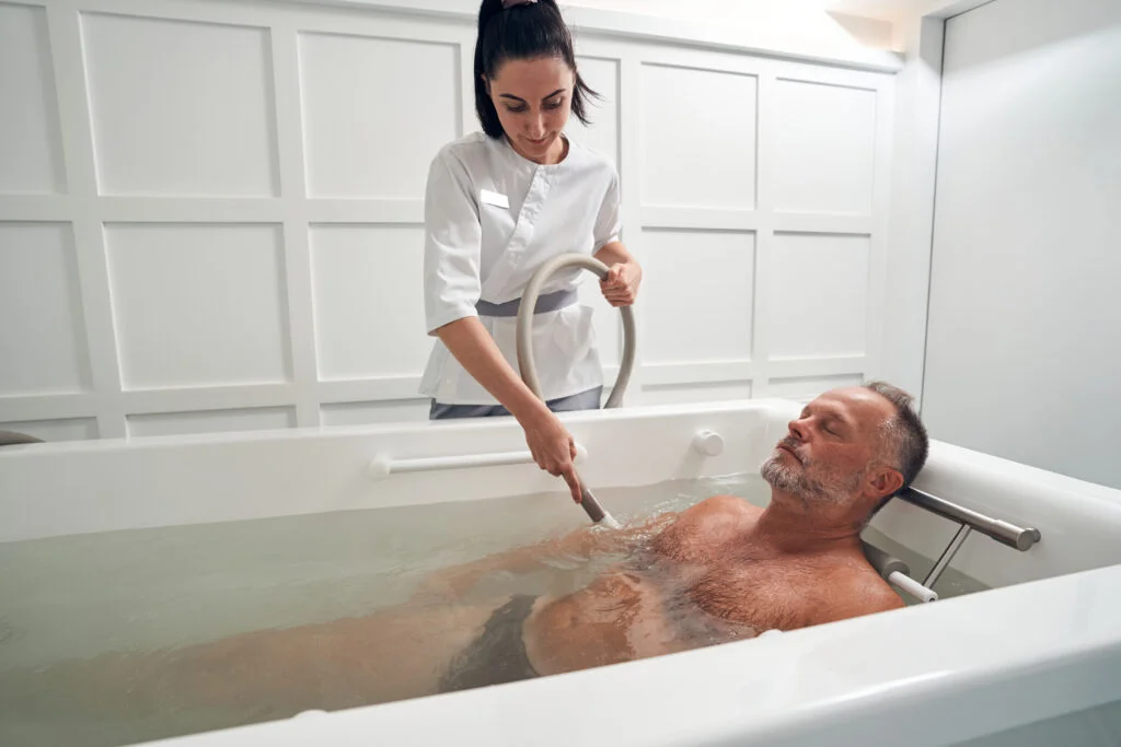 Male person having hydrotherapy procedure in spa salon